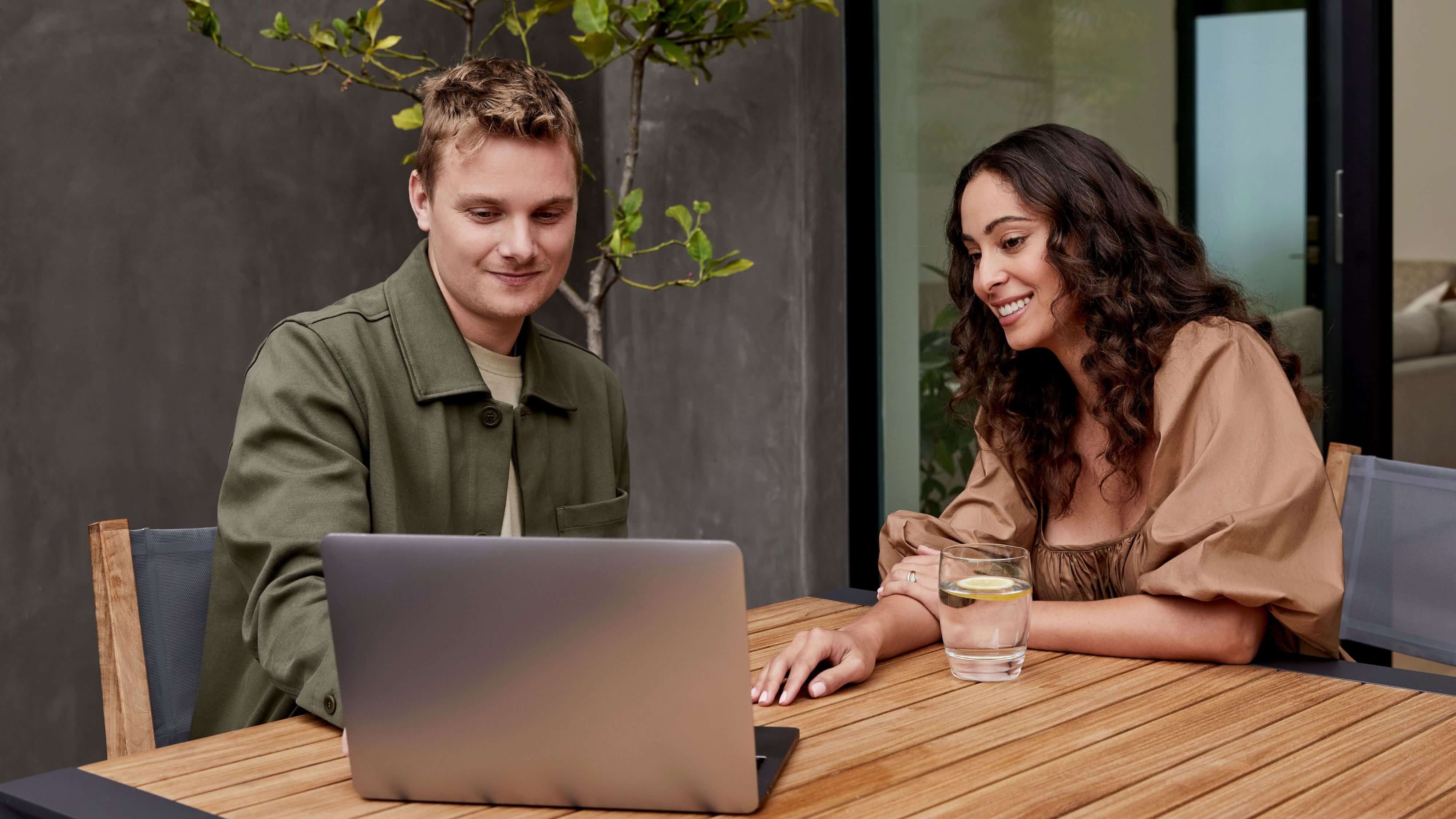 Woman using a laptop at an outdoor table, highlighting Outer outdoor furniture and effortless modern outdoor living