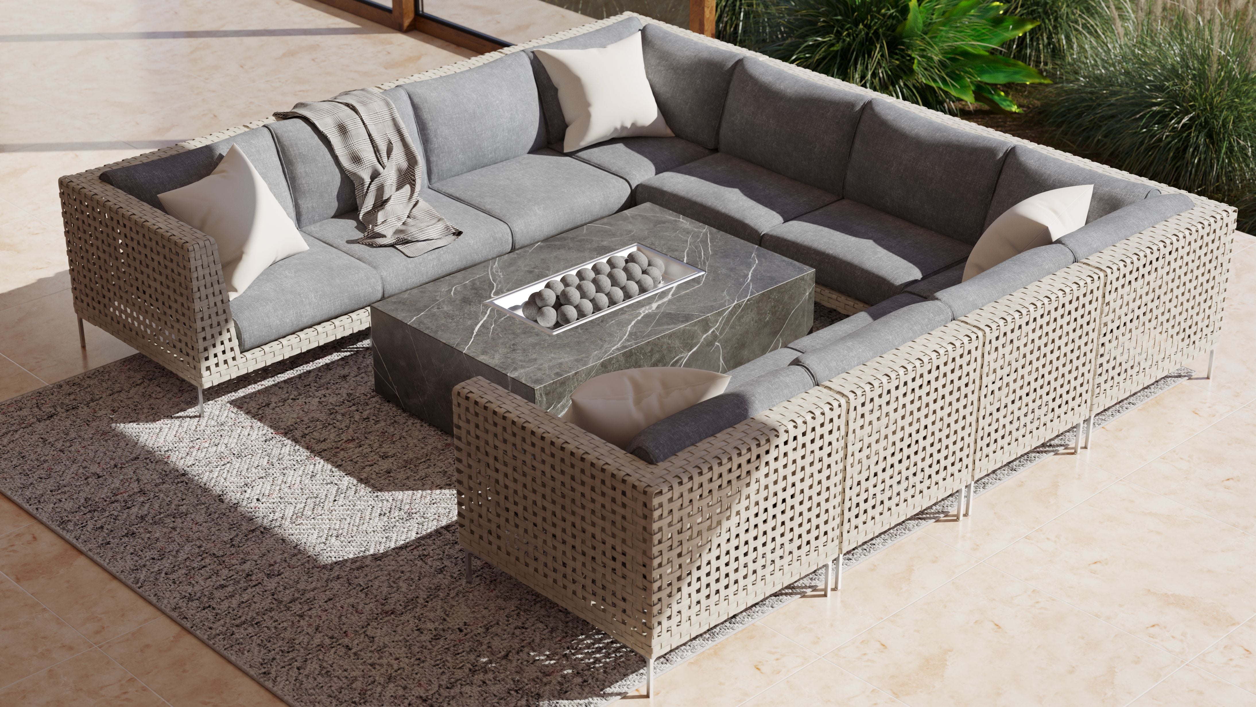 Outdoor sectional sofa arranged around a fire table on a textured outdoor rug