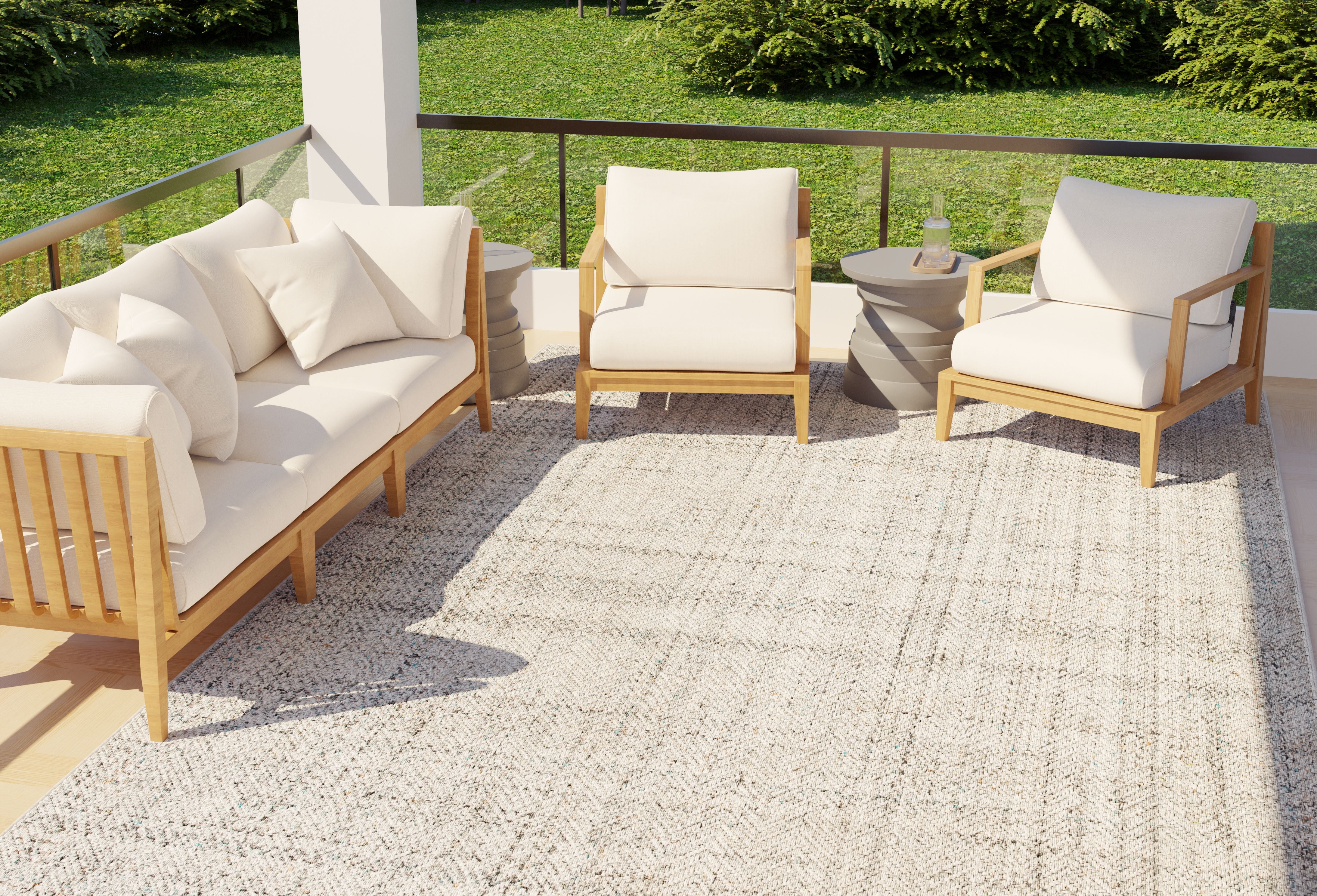 Modular outdoor sofa with textured cushions and a concrete side table, styled in a modern patio setting