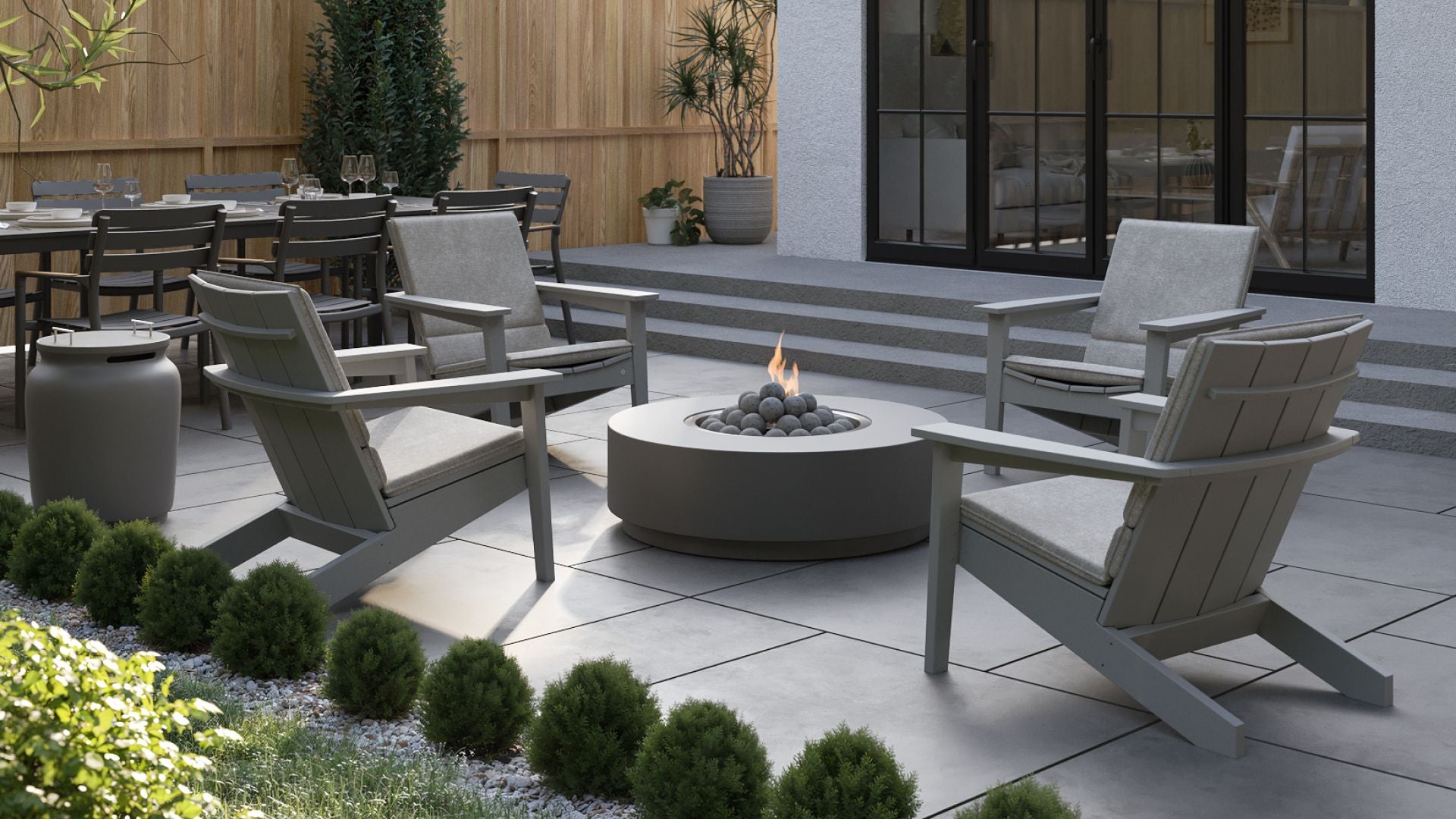 Outdoor patio area with Ascent Adirondack Chair and fire pit table.