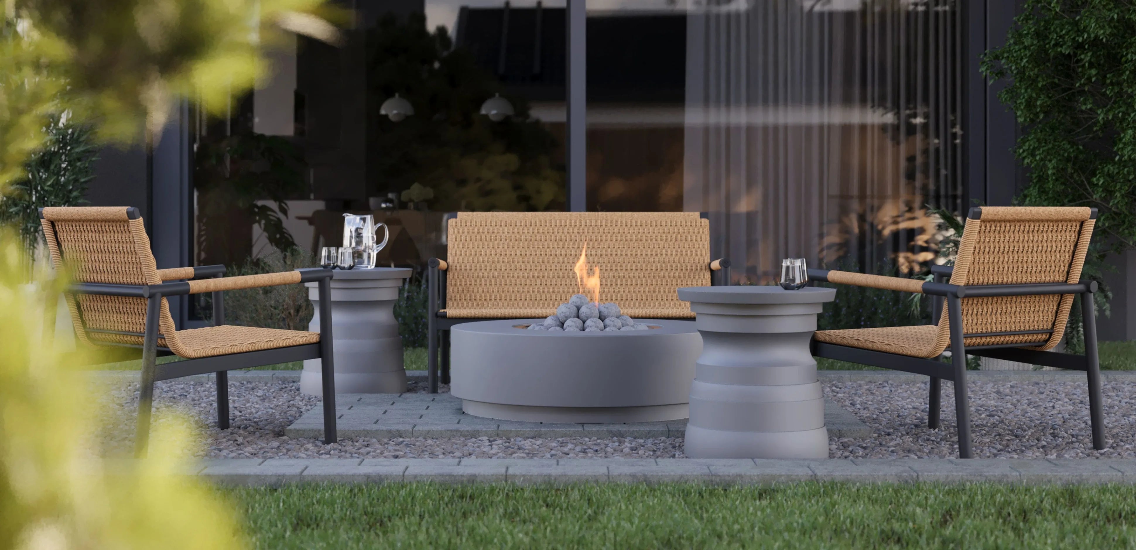 Outdoor seating from the Flex collection with woven chairs and a loveseat arranged around a fire pit on a patio
