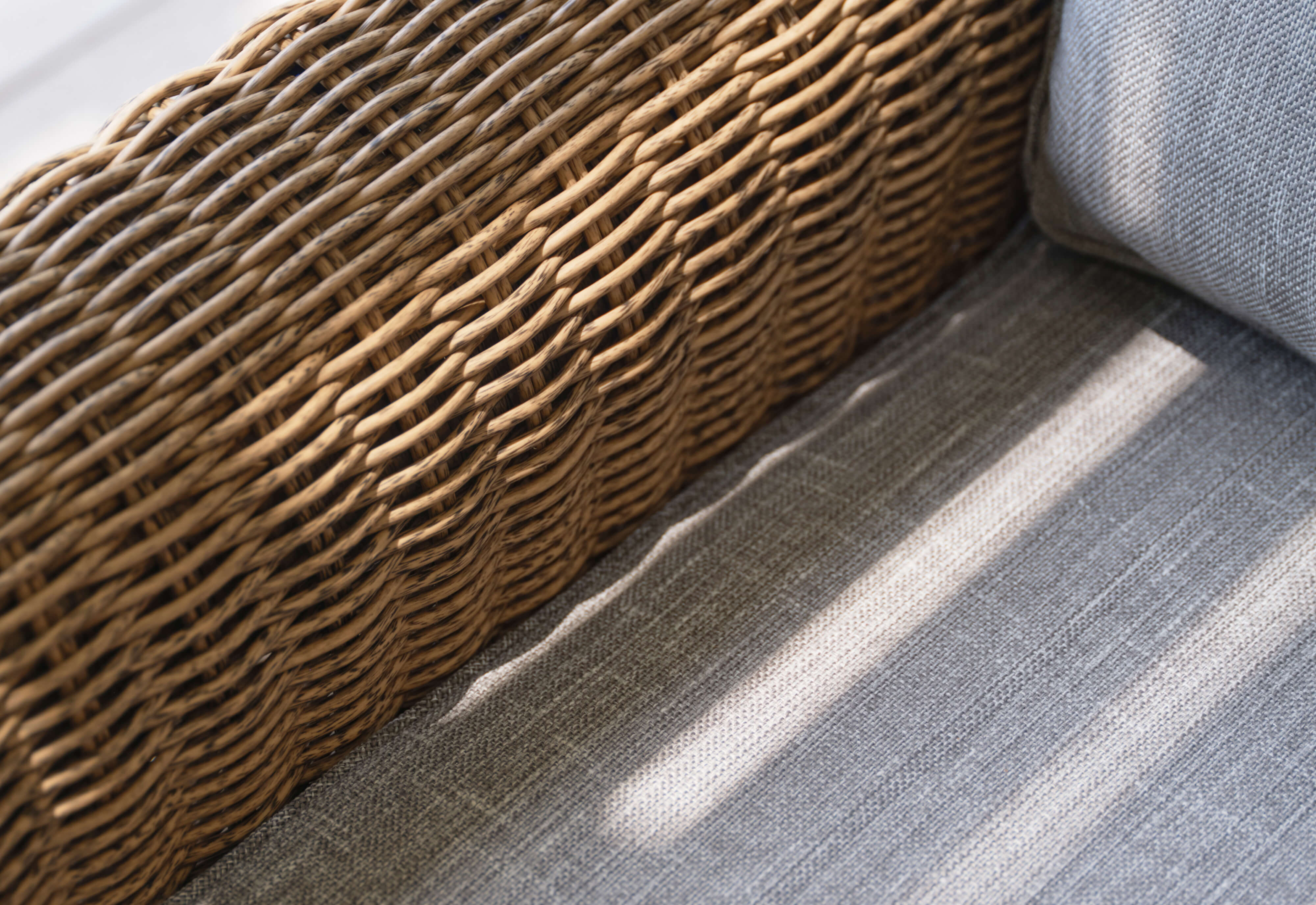 Closeup of the pacific fog gray cushion fabric and artisan all-weather brown wicker weave.