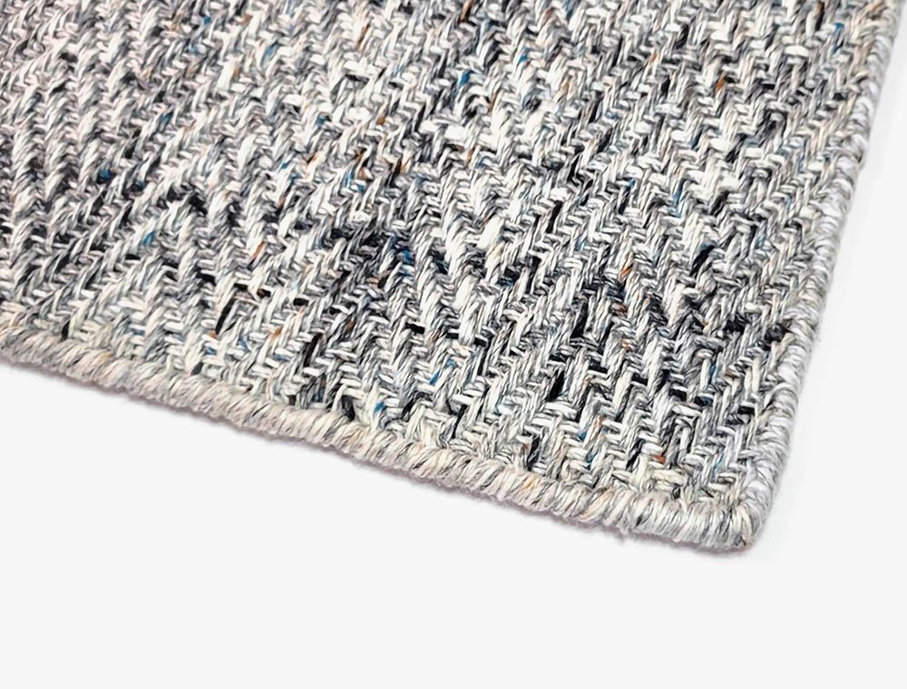 Eco-Friendly Outdoor Rug in Pebble Gray, corner closeup. Durable and sustainable outdoor rug made from recycled plastic bottles. #color_Pebble Gray