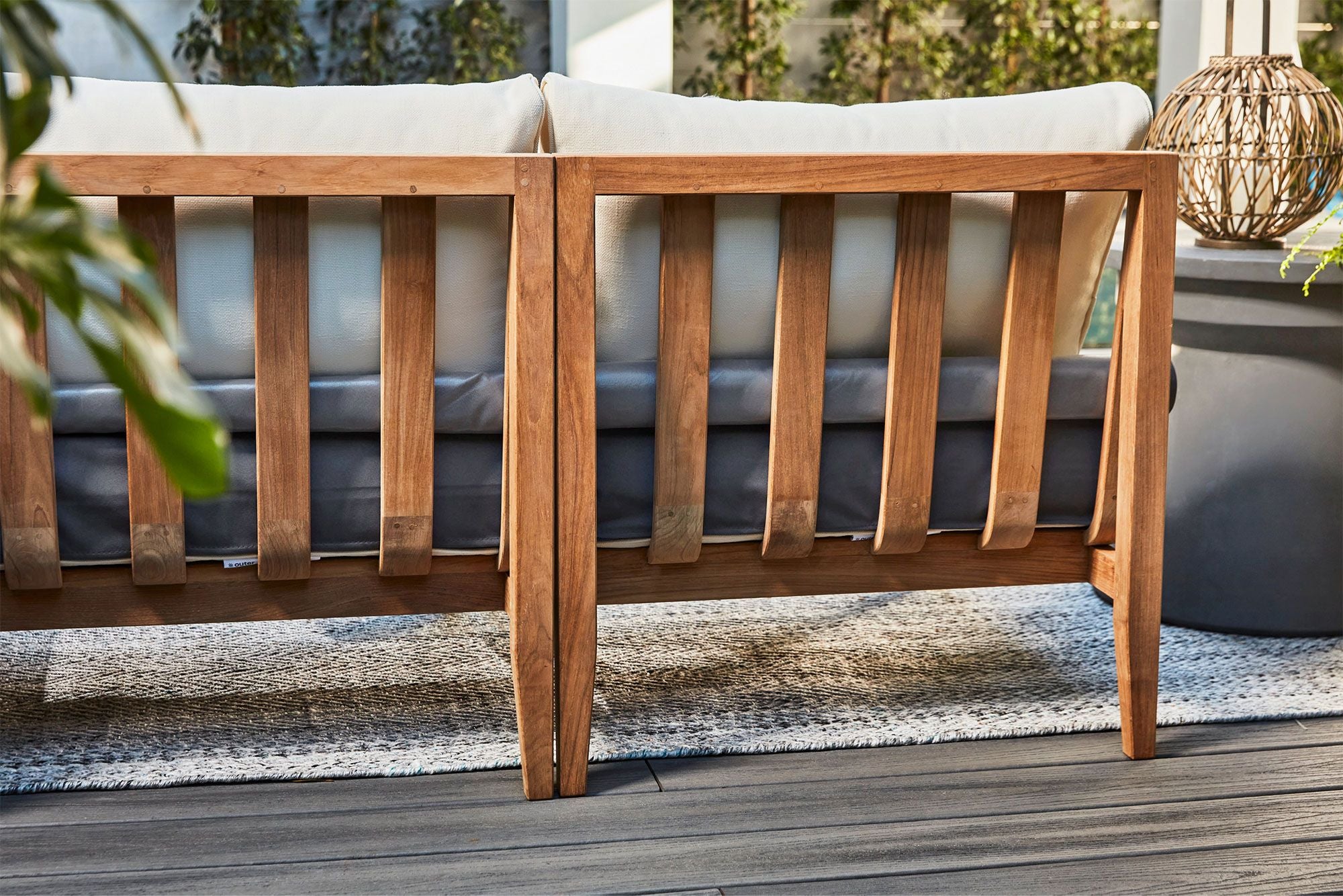 Teak outdoor sofa with matching armchairs, featuring a sturdy wooden frame and white cushions, shown from the back on a white background.-teak outdoor sofa-outer